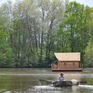 Cabane flottante dans les Pays de la Loire, entourée de verdure et deau paisible.
