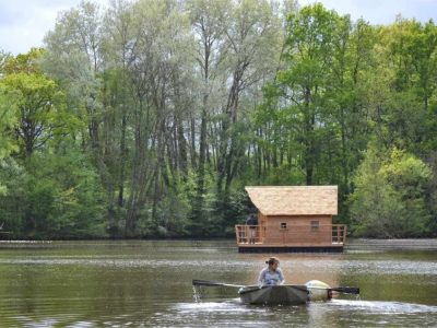 Cabane flottante dans les Pays de la Loire, entourée de verdure et deau paisible.