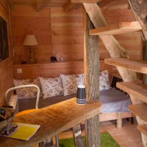 Cabane en bois cosy avec un escalier en colimaçon et un coin salon accueillant.