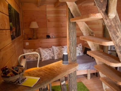 Cabane en bois cosy avec un escalier en colimaçon et un coin salon accueillant.
