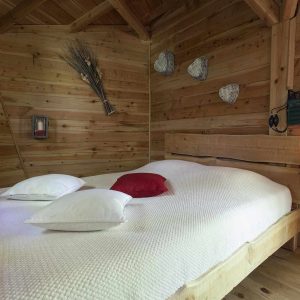 Chalet en bois chaleureux avec lit douillet et décoration naturelle.