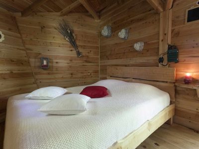 Chalet en bois chaleureux avec lit douillet et décoration naturelle.