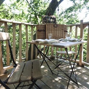 Cabane perchée en Auvergne-Rhône-Alpes avec vue sur la nature et mobilier en bois.