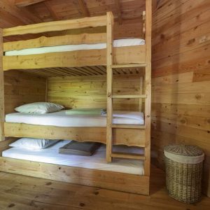 Chalet en bois avec lits superposés, ambiance chaleureuse et naturelle en Auvergne.