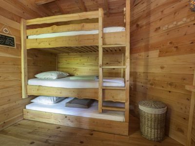 Chalet en bois avec lits superposés, ambiance chaleureuse et naturelle en Auvergne.