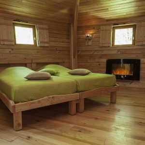 Chalet en bois chaleureux avec lits doubles et cheminée, au cœur de lAuvergne.