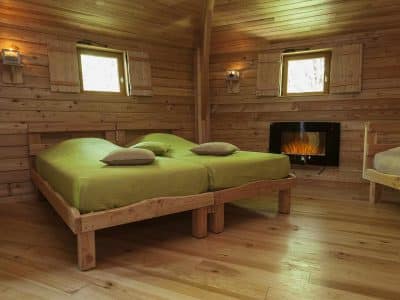 Chalet en bois chaleureux avec lits doubles et cheminée, au cœur de lAuvergne.
