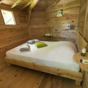 Chalet en bois chaleureux avec lit douillet et décoration naturelle.
