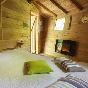 Chalet en bois chaleureux avec lit douillet et décoration moderne à Auvergne-Rhône-Alpes.