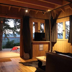 Cabane en bois avec vue panoramique sur la nature, ambiance chaleureuse et cosy.