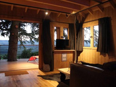 Cabane en bois avec vue panoramique sur la nature, ambiance chaleureuse et cosy.