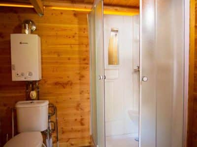 Cabane en bois avec salle de bain moderne, douche et toilettes intégrées.
