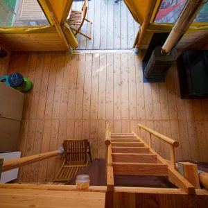 Cabane en bois lumineuse avec une mezzanine et un coin cuisine.