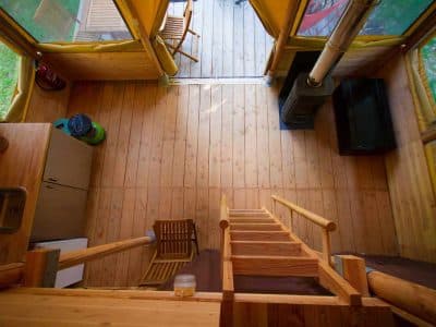 Cabane en bois lumineuse avec une mezzanine et un coin cuisine.
