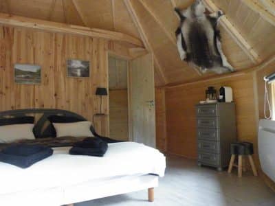 Cabane en bois à Champagne-Ardennes, avec un intérieur chaleureux et un plafond en bois.
