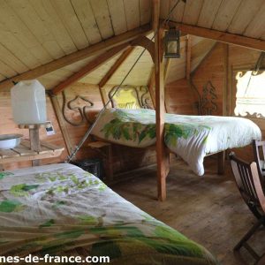 Cabane en bois cosy avec lits jumeaux et décor naturel en Haute-Normandie.