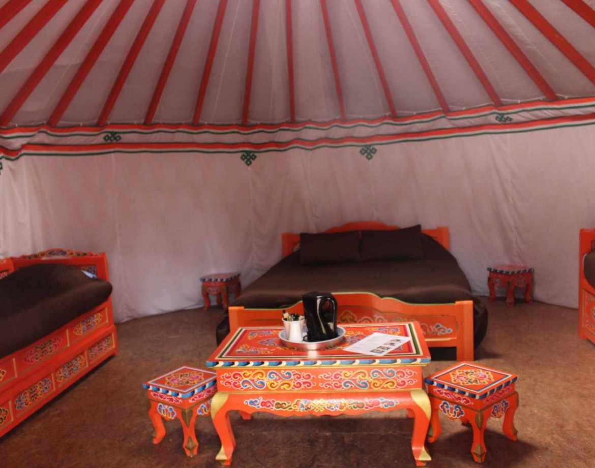 Yourte colorée avec mobilier traditionnel, située dans le Pays de la Loire.