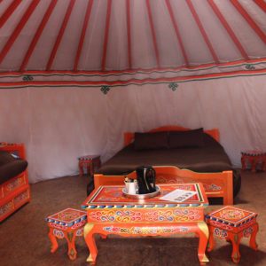 Yourte colorée avec mobilier traditionnel, située dans le Pays de la Loire.