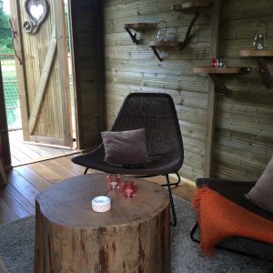 Cabane en bois à Ile-de-France, avec un salon cosy et une porte en forme de cœur.