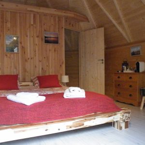 Chalet en bois chaleureux avec lit douillet et décor en bois naturel.