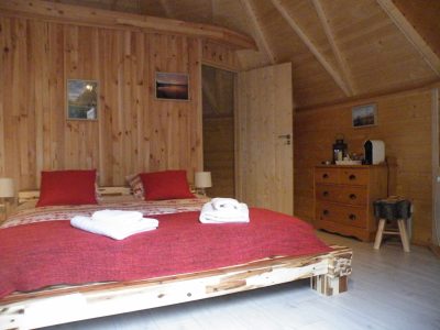 Chalet en bois chaleureux avec lit douillet et décor en bois naturel.