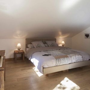 Chambre cosy en hébergement insolite, avec lit double et lumière douce.