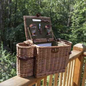 Panier pique-nique en osier sur une terrasse bois, entouré de verdure en Auvergne-Rhône-Alpes.
