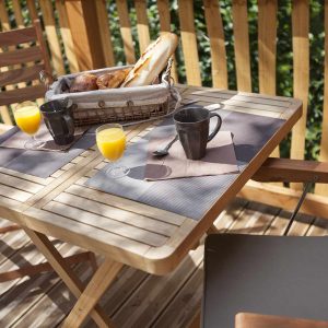 Table en bois sur une terrasse, avec petit-déjeuner et vue sur la nature en Auvergne.