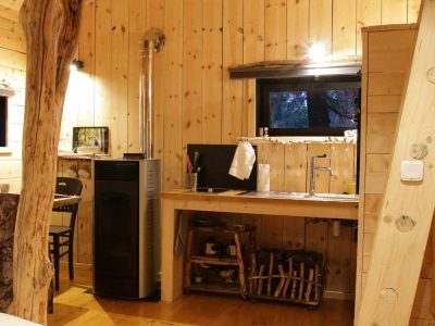 Cabane en bois à Bourgogne-Franche-Comté, avec un intérieur chaleureux et un poêle.