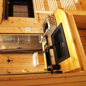Cabane en bois avec un lavabo en pierre et des accessoires en osier.