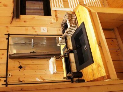 Cabane en bois avec un lavabo en pierre et des accessoires en osier.