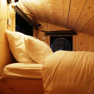 Cabane en bois cosy avec lit douillet et ambiance chaleureuse à Bourgogne-Franche-Comté.