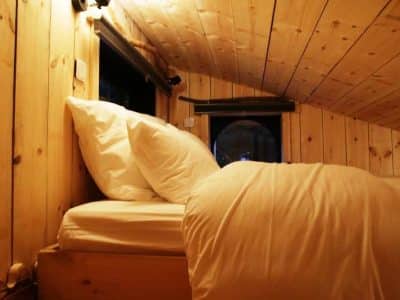 Cabane en bois cosy avec lit douillet et ambiance chaleureuse à Bourgogne-Franche-Comté.