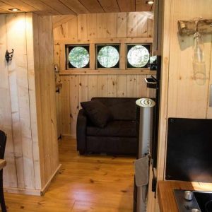 Hébergement insolite en Bourgogne-Franche-Comté, intérieur en bois avec fenêtres rondes.