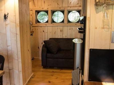 Hébergement insolite en Bourgogne-Franche-Comté, intérieur en bois avec fenêtres rondes.