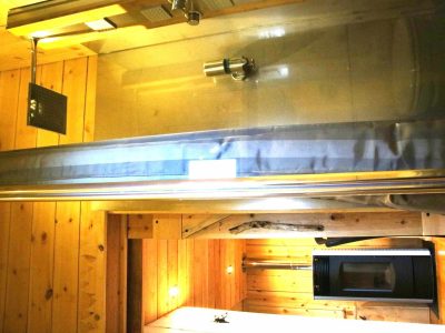 Hébergement insolite en bois avec baignoire moderne et éclairage chaleureux.