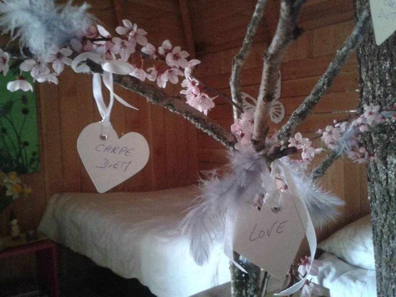Cabane cosy avec décor floral, ambiance chaleureuse et romantique.