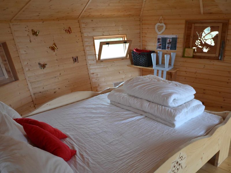 Chalet en bois chaleureux avec lit douillet et décorations en bois.