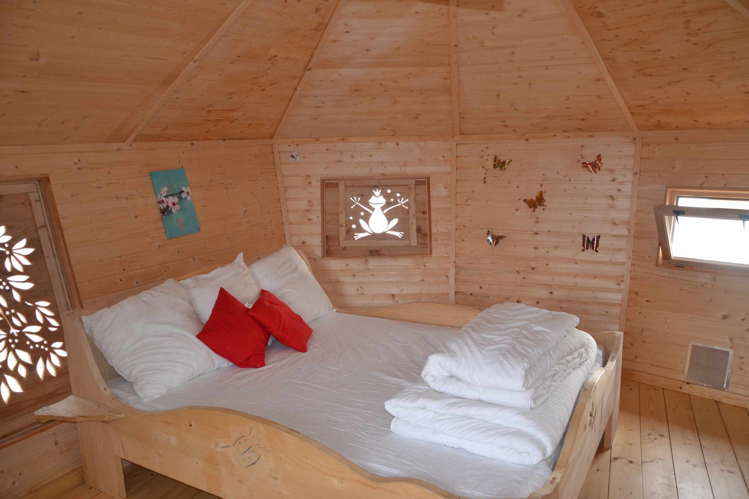 DSC_0305 Cabane en bois avec lit douillet et décorations murales colorées.