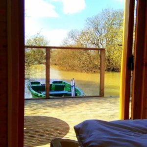 Cabane sur pilotis en Nouvelle-Aquitaine, vue sur un bateau et la rivière.
