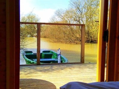 Cabane sur pilotis en Nouvelle-Aquitaine, vue sur un bateau et la rivière.