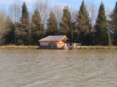 Cabane flottante en bois sur leau, entourée darbres en Nouvelle-Aquitaine.