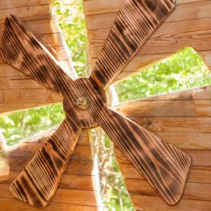 Hébergement insolite en bois avec un ventilateur artisanal en bois, ambiance nature.