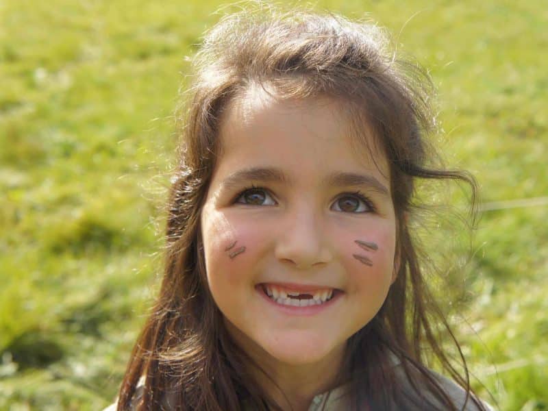 Enfant souriante dans un cadre naturel, parfait pour un séjour en camping.