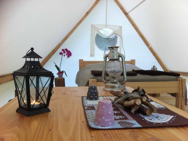 Tente lodge en Auvergne-Rhône-Alpes, avec lanternes et décoration en bois.