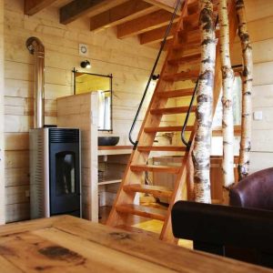 Cabane en bois avec escalier en colimaçon et décoration chaleureuse.