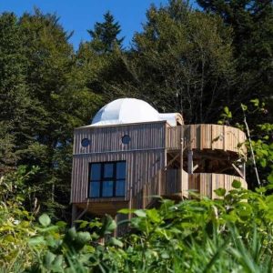 Cabane en bois avec dôme, entourée de verdure en Bourgogne-Franche-Comté.