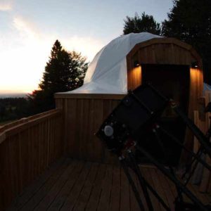 Dôme en bois avec télescope, offrant une vue imprenable sur le coucher de soleil.