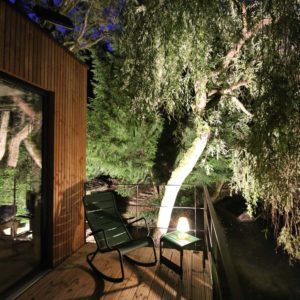 Cabane en bois à Bourgogne, avec terrasse éclairée et vue sur la nature.