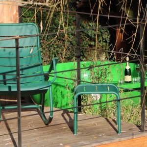 Hébergement insolite en Bourgogne avec chaises vertes et baignoire extérieure.